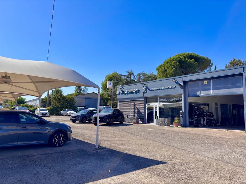 Bâtiment de Bédarieux Automobiles, route de Saint-Pons, avec son parc de véhicules et ses barnums